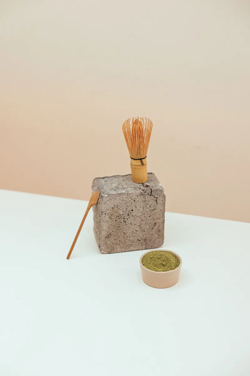 Batidor chasen de bambú para matcha sobre superficie de piedra