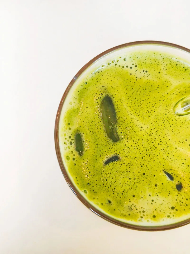 Vaso de matcha frío verde intenso sin leche, servido con hielo