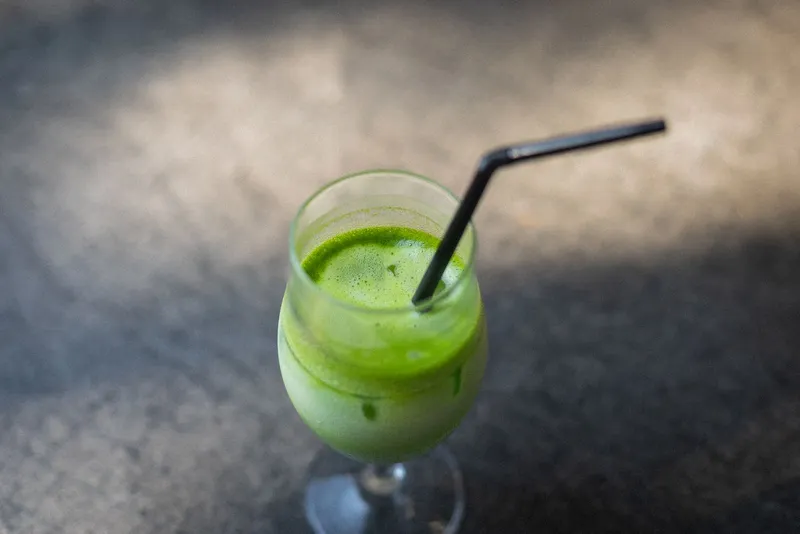 Matcha latte helado en vaso con pajita visto desde arriba